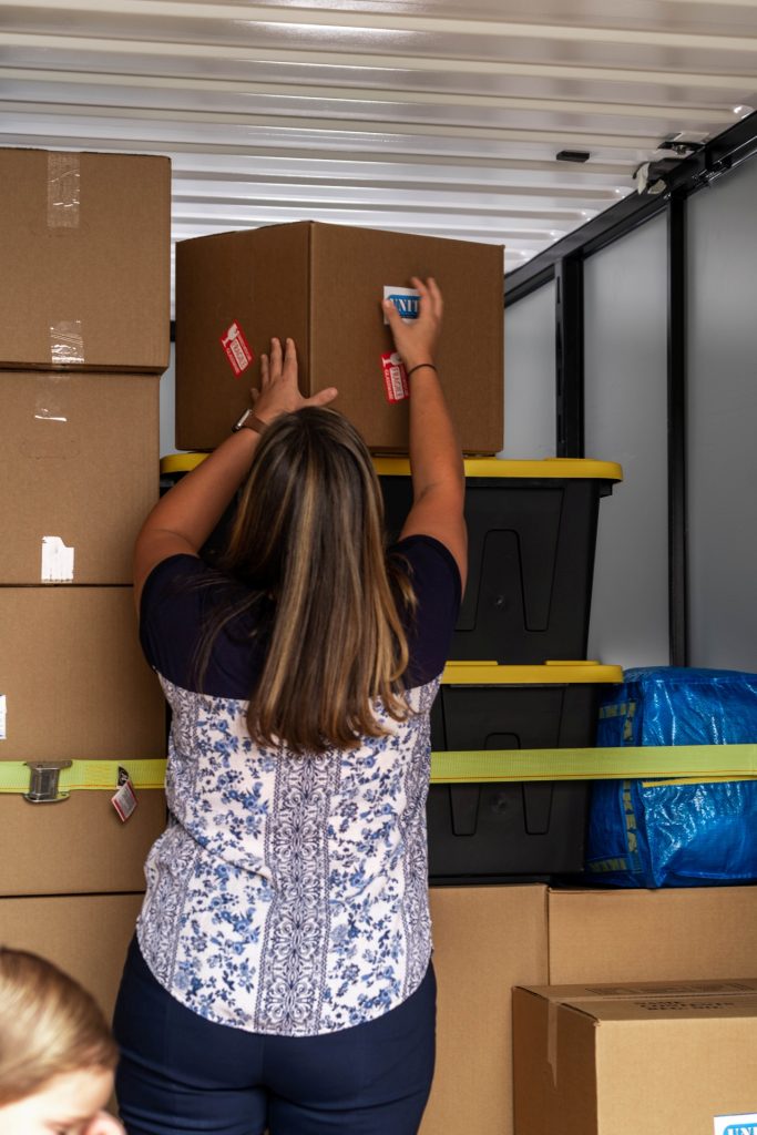 image of a woman placing packed boxes into a portable storage container