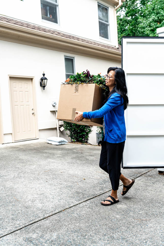 woman carrying a box while moving with portable storage in redwood city